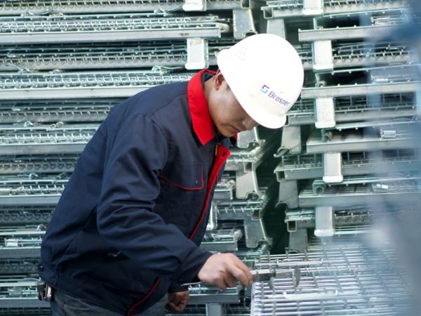 Un personal de control de calidad está probando el tamaño de la malla del contenedor de malla de alambre.